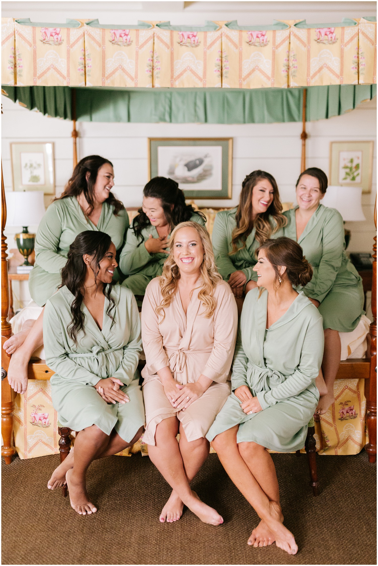 bride sits with bridesmaids on bed at Old Edwards Inn