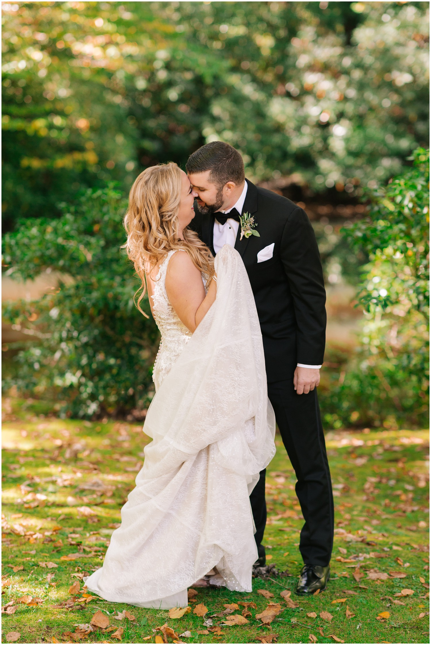 bride and groom kiss during first look while bride holds up underskirt of wedding dress
