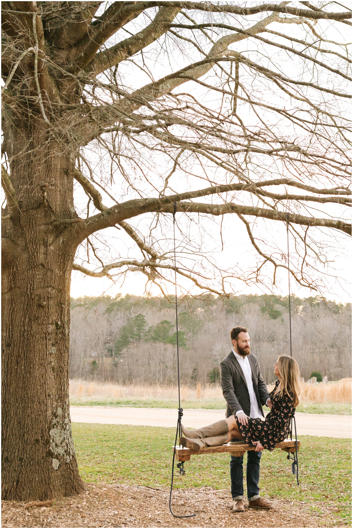 bride sits on wooden swing during NC engagement session