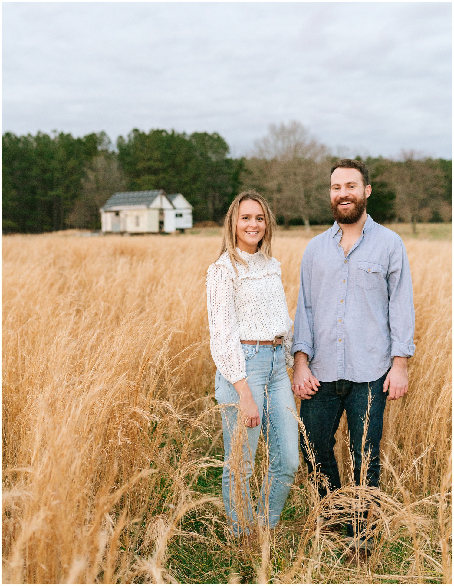 couple holds hand in field at The Meadows Raleigh