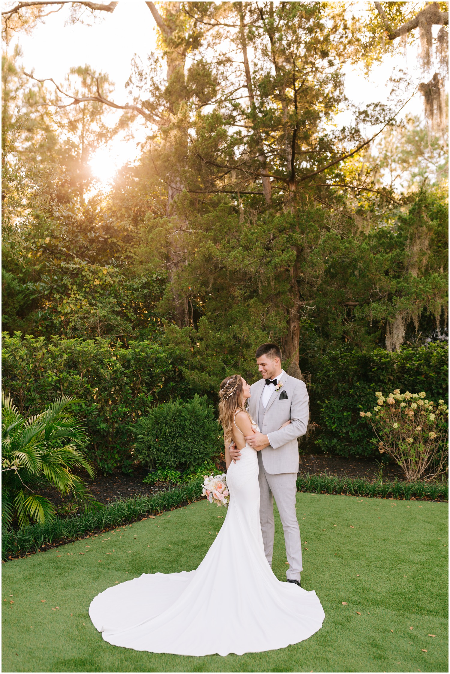 sunset wedding portraits of bride in classic wedding gown and groom in grey suit