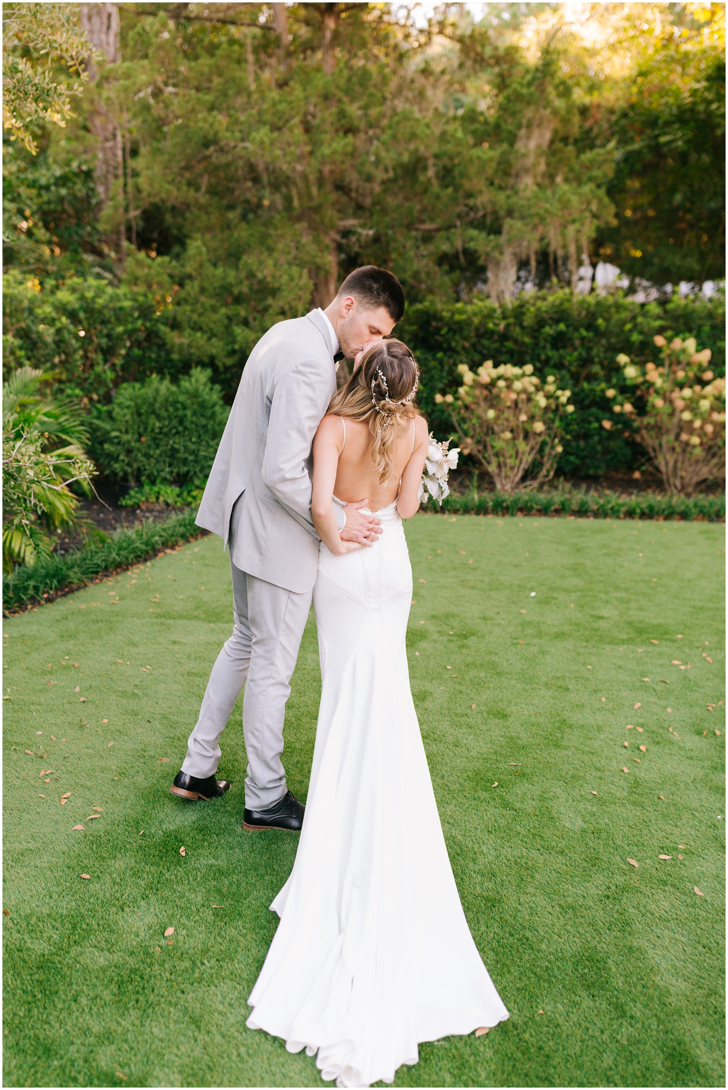 groom kisses bride in Wrightsville Manor gardens