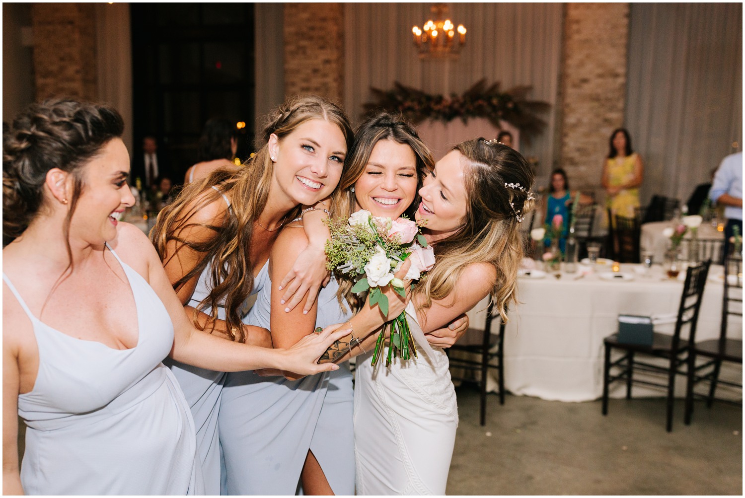 bridesmaids ug bride after bouquet toss during Wilmington NC wedding reception