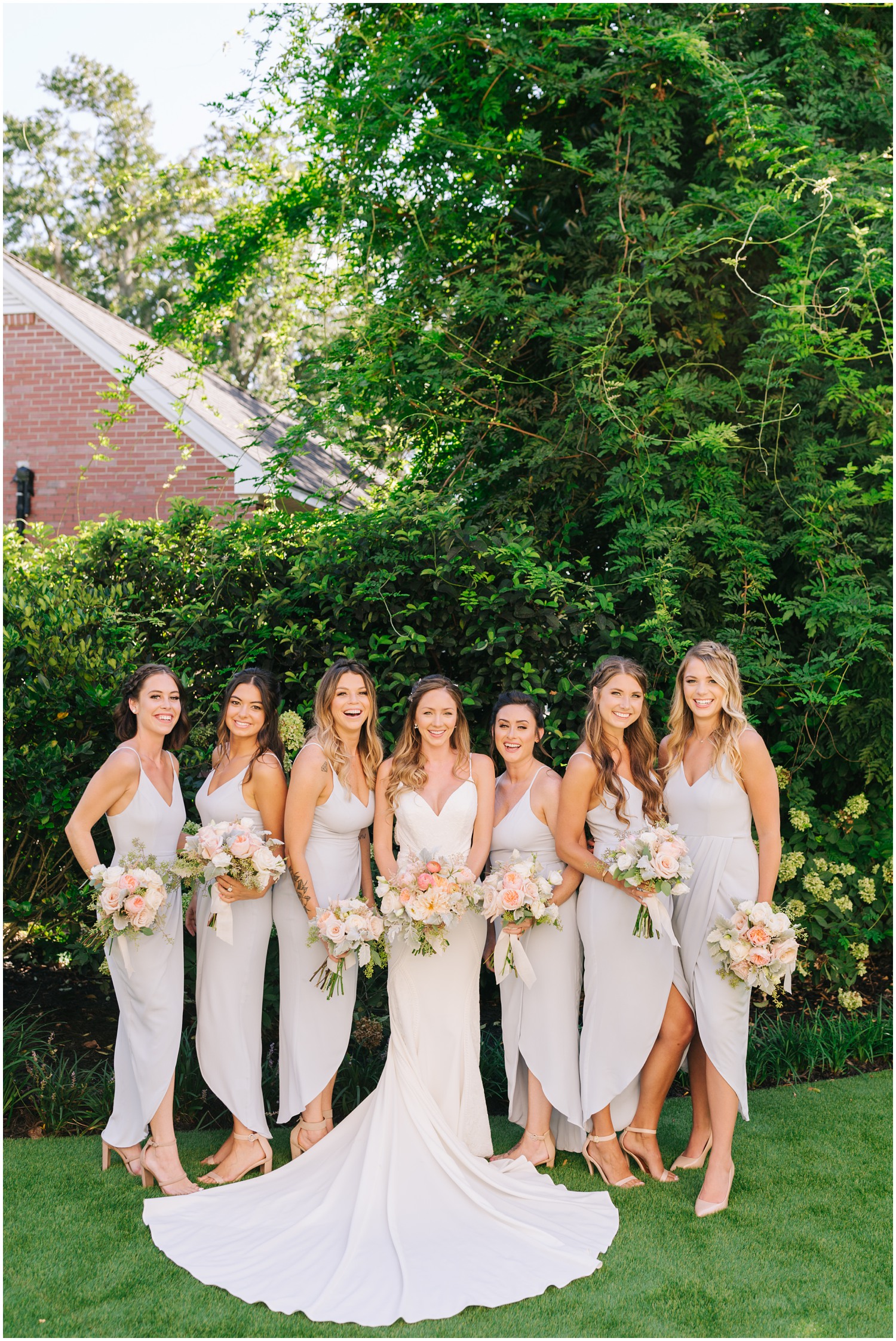 bridesmaids in dusty blue gowns pose with bride in North Carolina