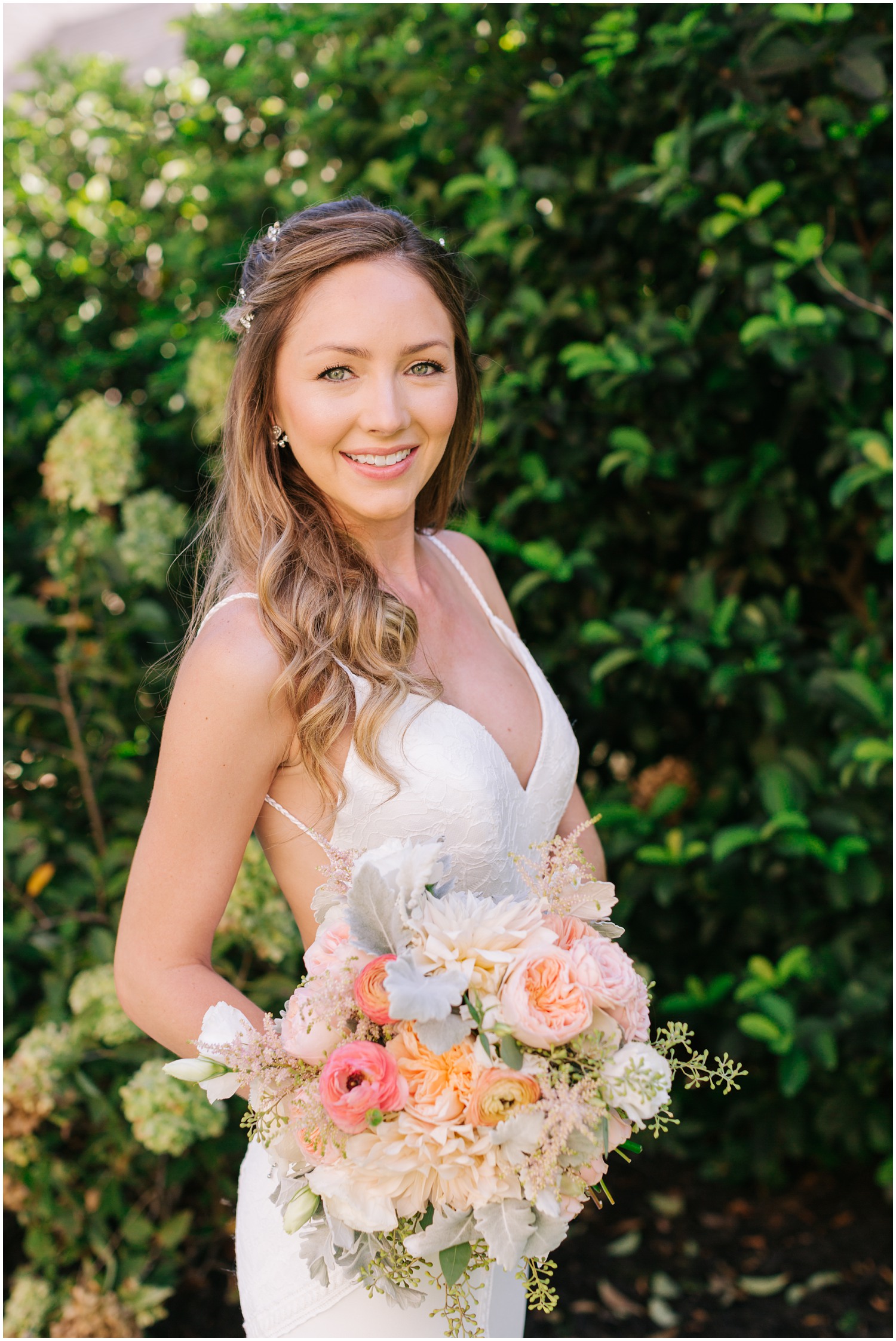 bride holds pastel bouquet with coral pops of color