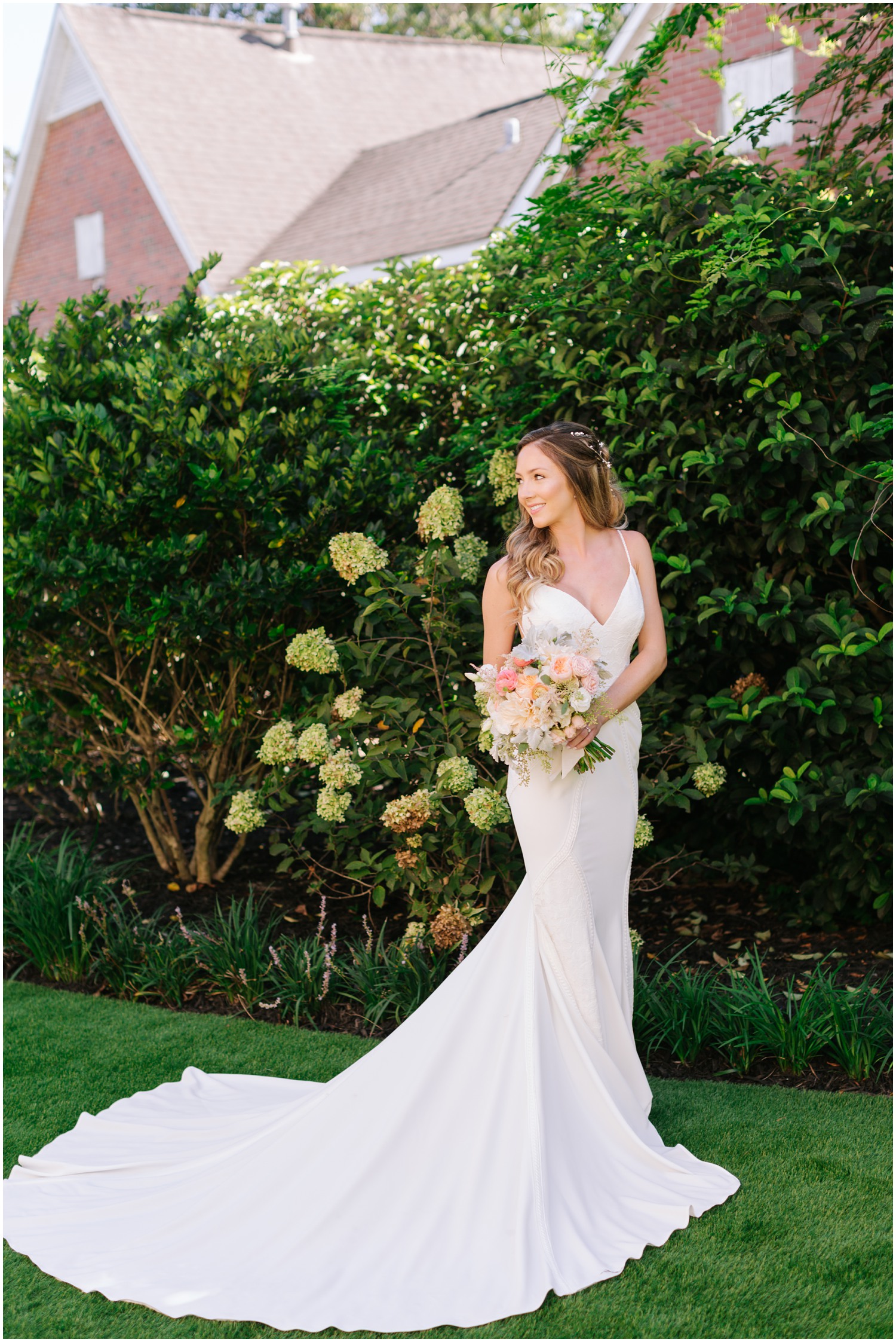 bride holds bouquet to side during bridal portraits in gardens