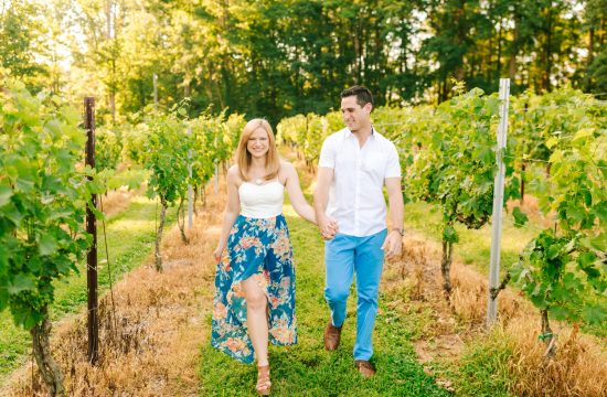 a couple walking through a vineyard at Sanders Ridge Winery