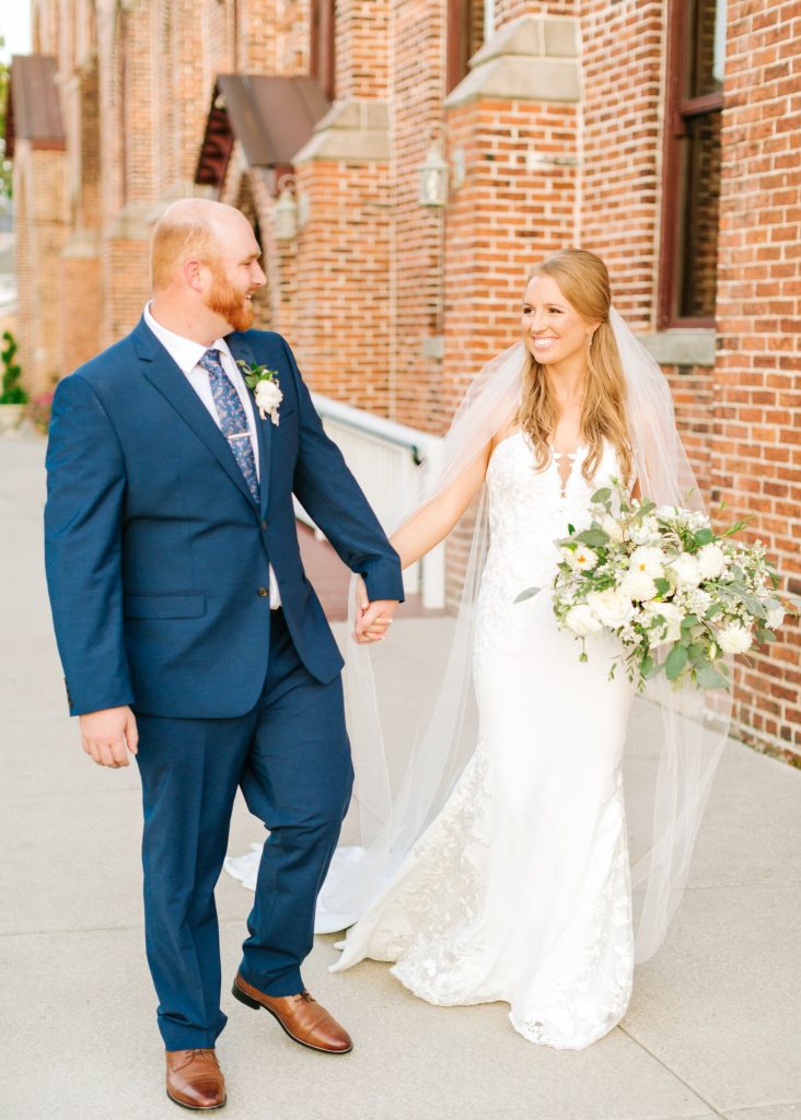 bride and groom walk through Wilmington NC after wedding ceremony