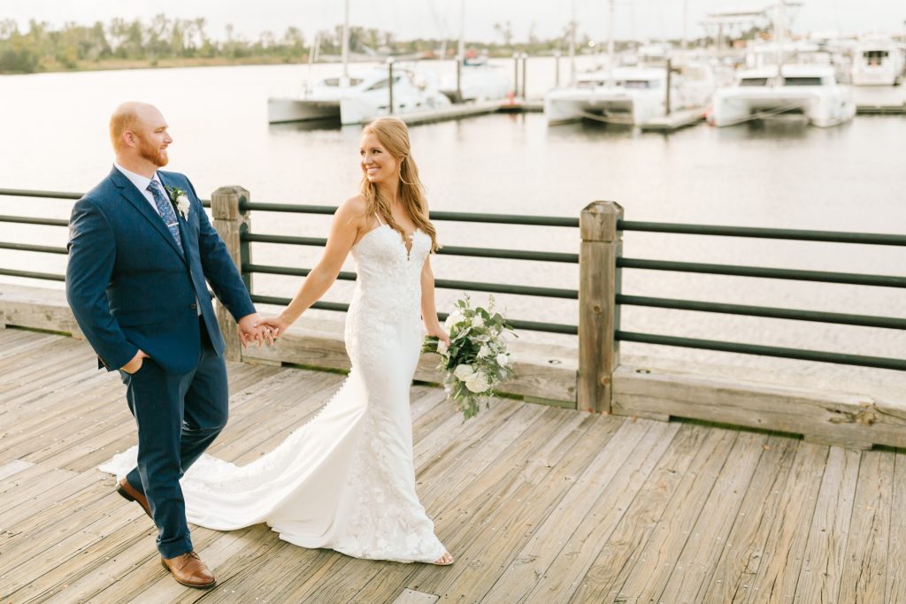 bride and groom walk along dock in Wilmington NC