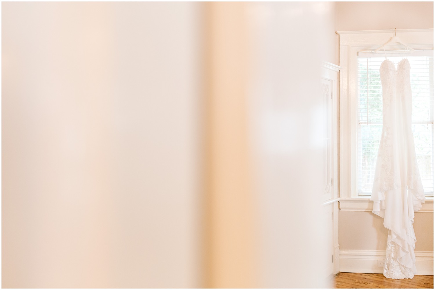 wedding dress hangs in window of childhood home 