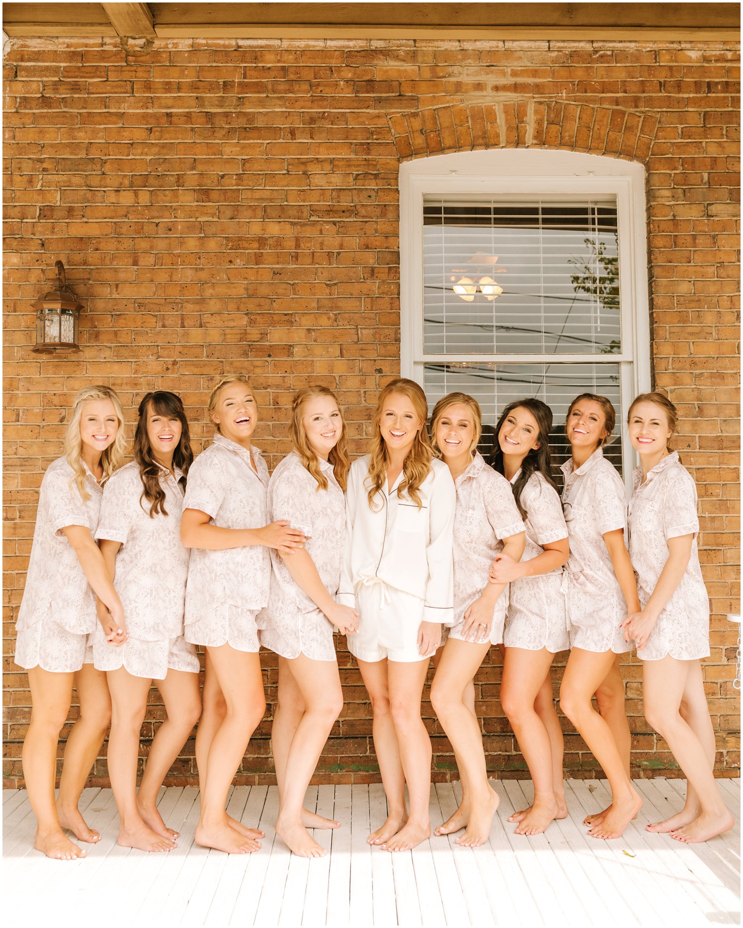 bride poses in matching pajamas with bridesmaids before Brooklyn Arts Center wedding