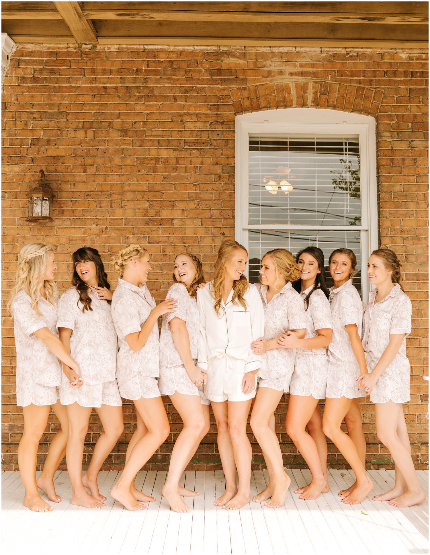 bride poses in matching pajamas with bridesmaids