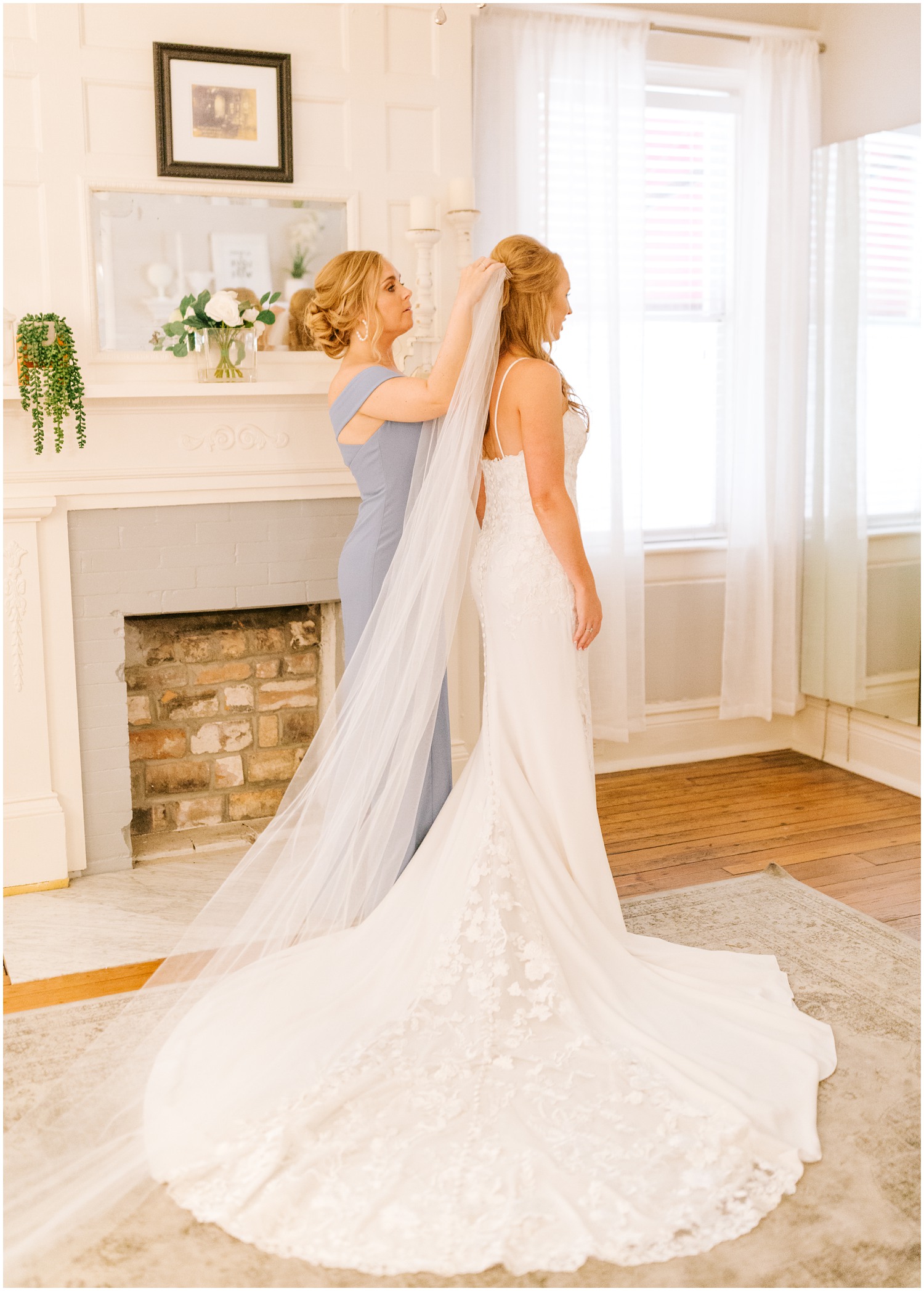 bridesmaid helps bride with veil before Brooklyn Arts Center wedding