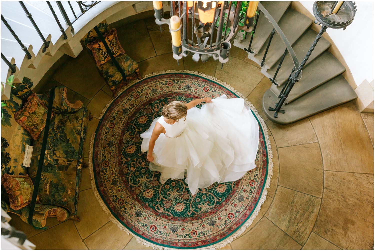 portrait of bride twirling in wedding gown from top of staircase in Graylyn Estate