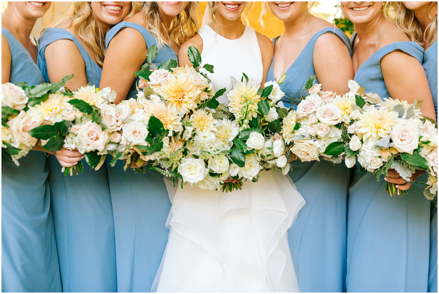 bridesmaids in cornflower blue dresses hold pink and ivory bouquets at Graylyn Estate