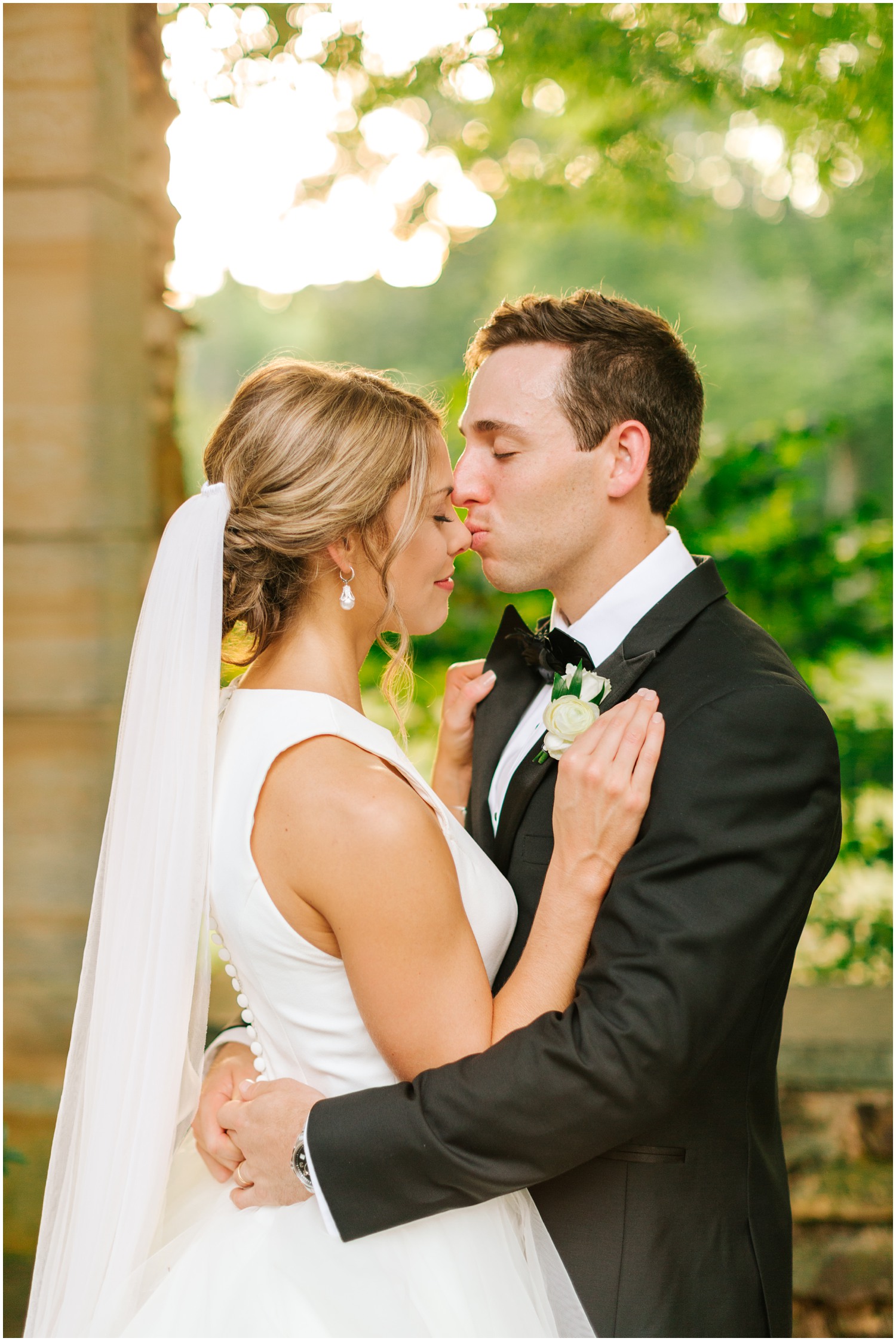 groom kisses new bride on the nose during portraits at Graylyn Estate
