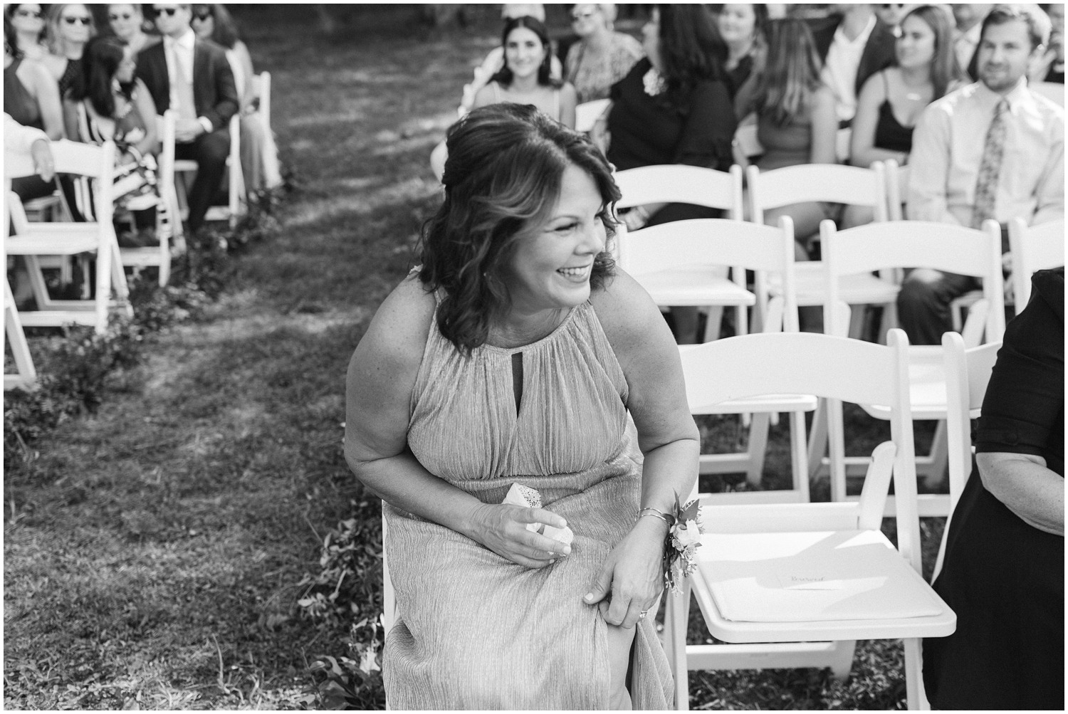 mother of the bride laughs during wedding ceremony