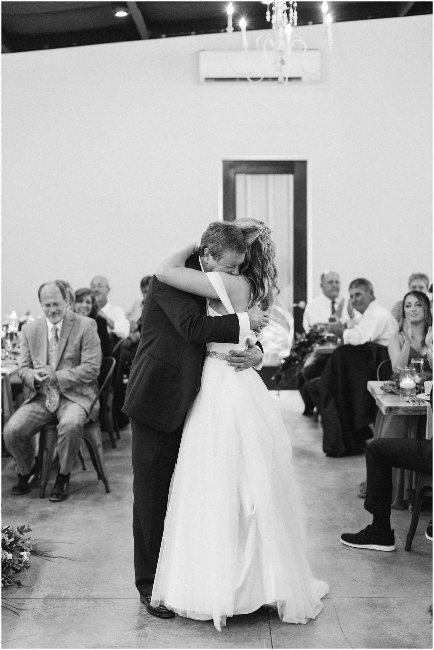 father hugs bride during dance at wedding reception