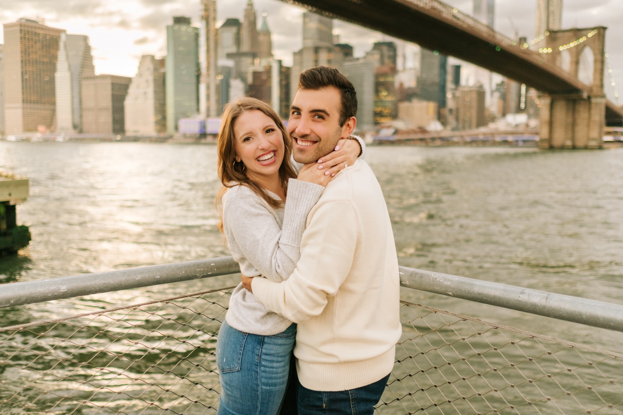 nyc wedding photographer captures engagement photos of a couple at Brooklyn Bridge Park overlooking the Manhattan skyline at Sunset