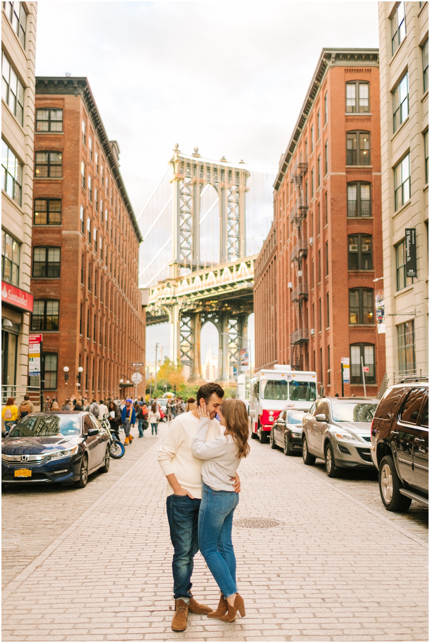 bride and groom kiss in front of Brooklyn Bridge during West Village & Dumbo engagement session