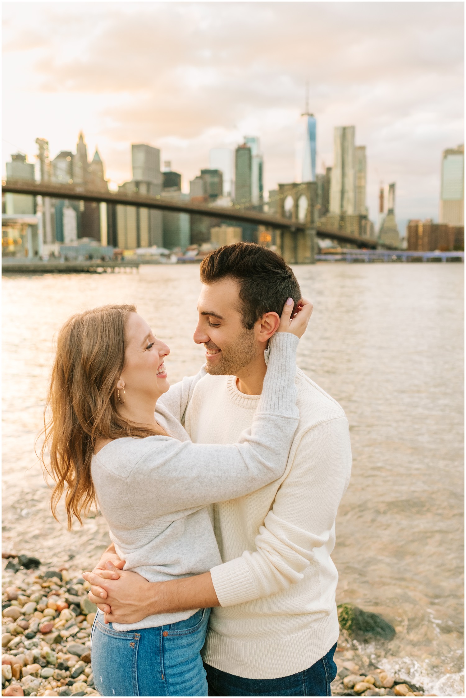 bride touches groom's hair posing by Hudson River in West Village & Dumbo