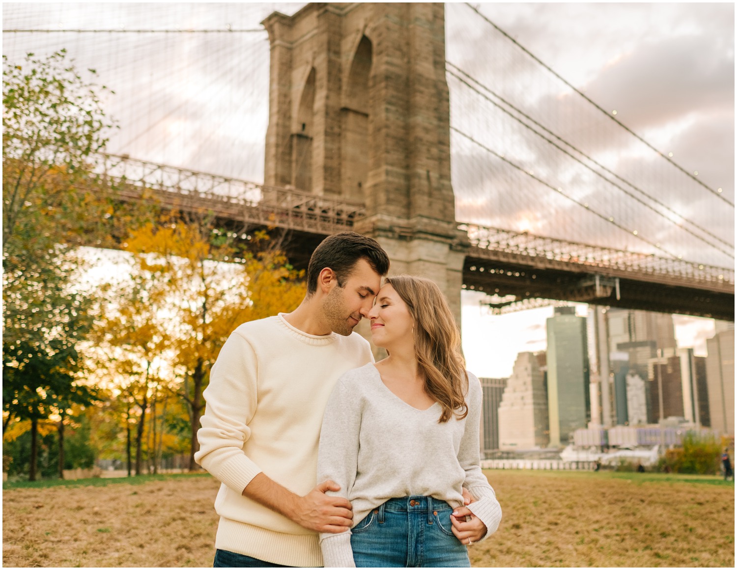 bride and groom stand nose to nose with eyes closed during DUMBO engagement session