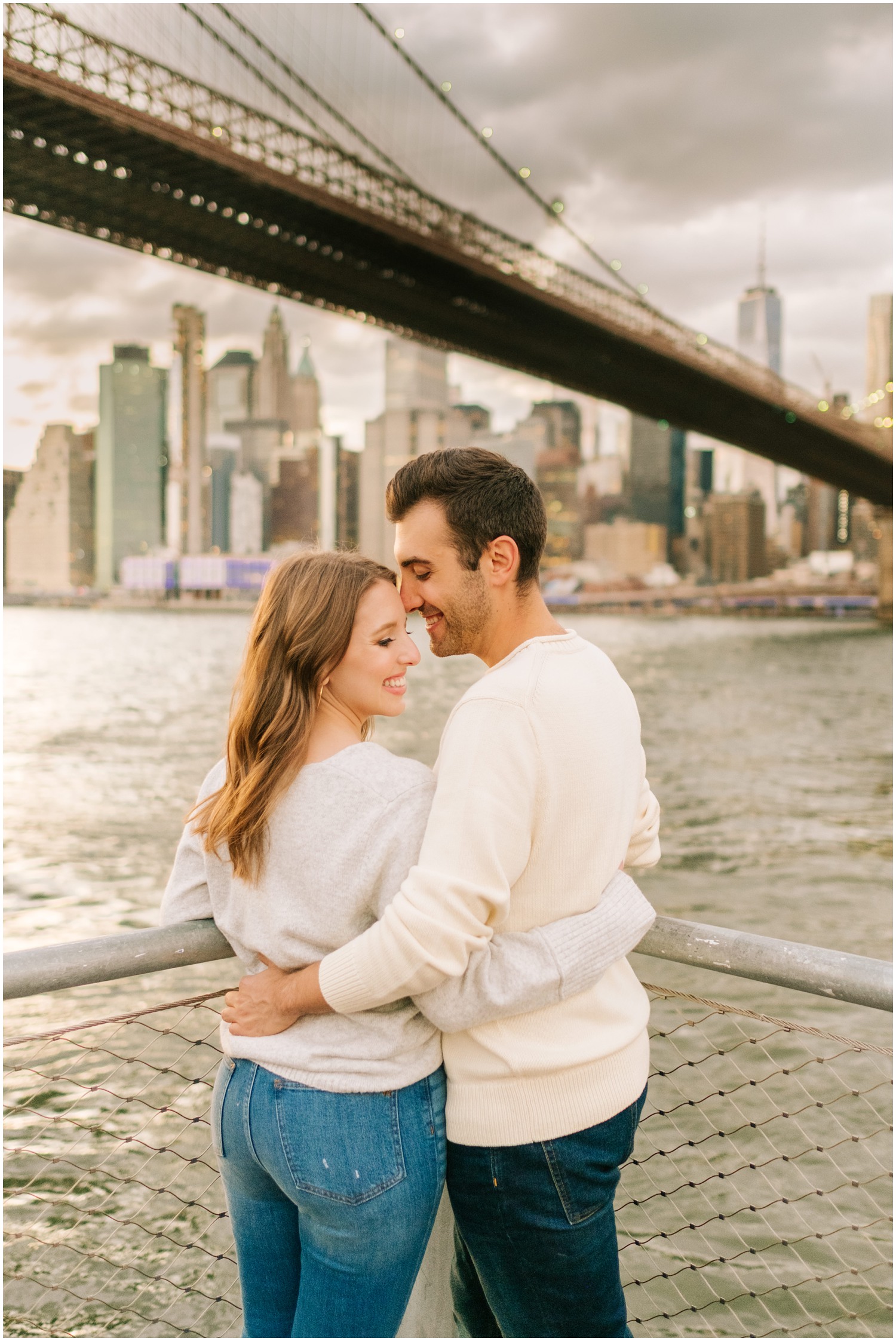 bride and groom in sweatshirts pose during West Village & Dumbo engagement session