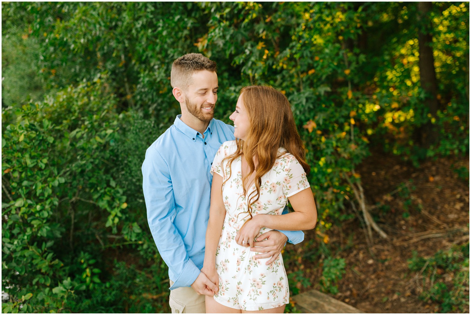 bride and groom look at each other laughing during engagement photos