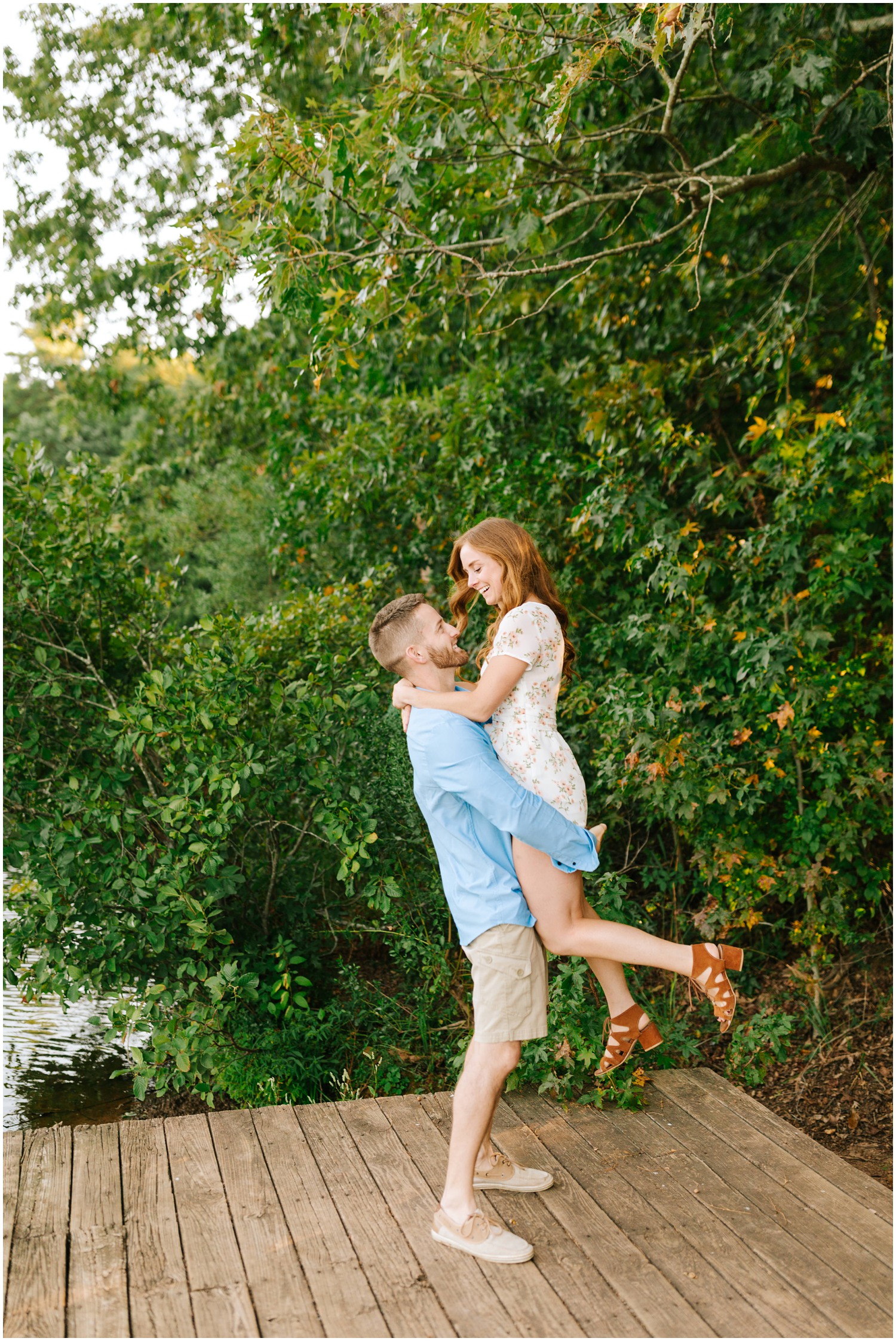 groom lifts fiancee during Lake Lyn engagement session
