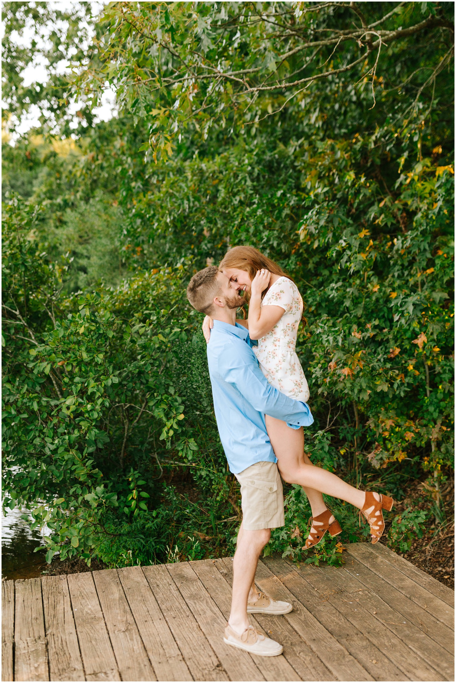 groom lifts bride during lakeside engagement session