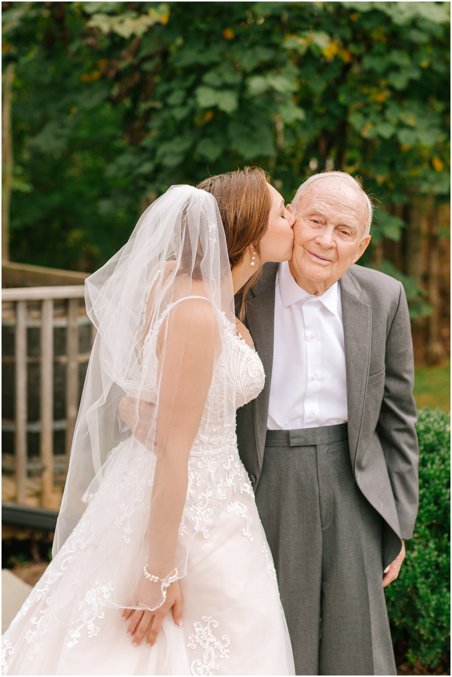 bride kisses grandfather on the cheek before wedding day