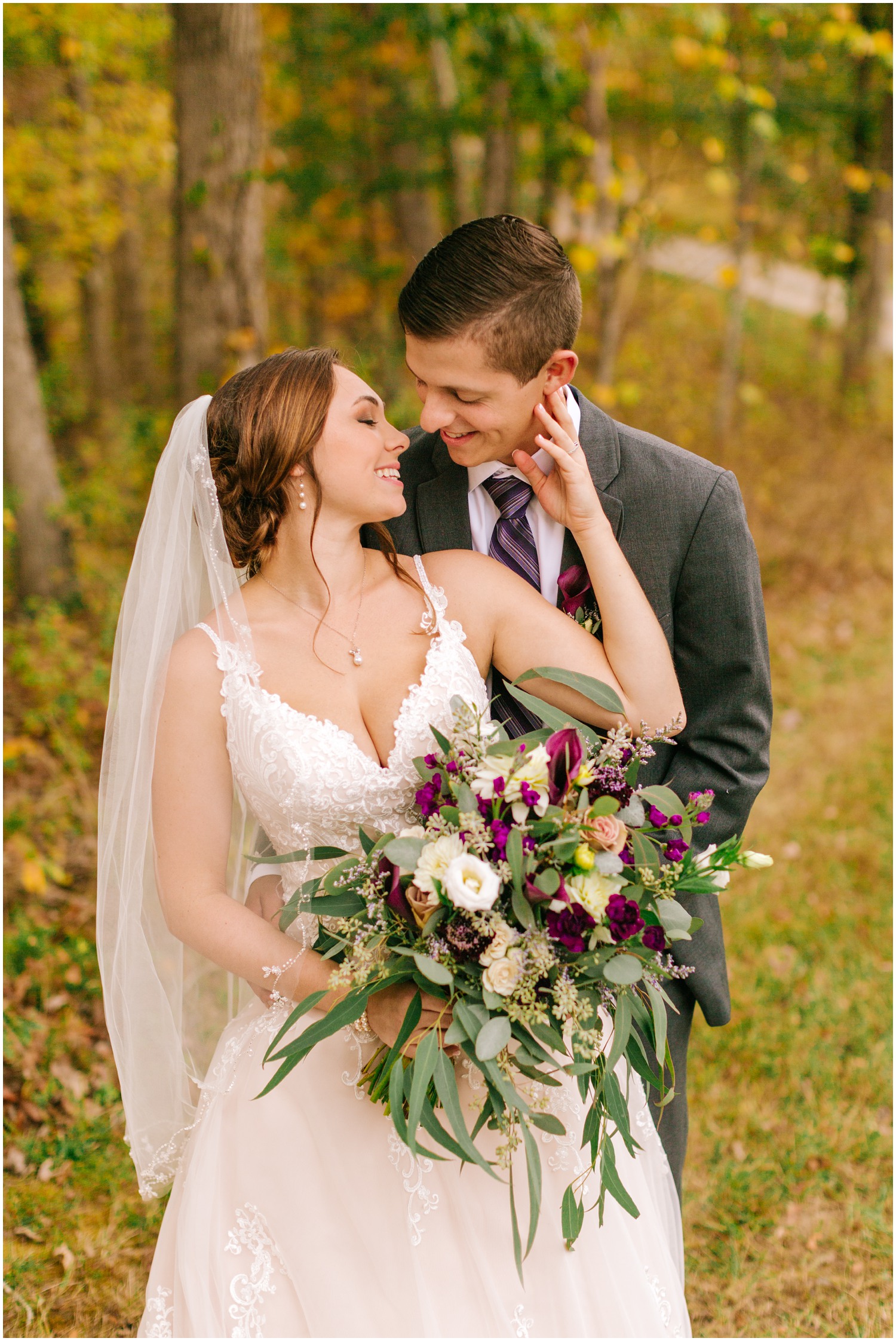 bride holds groom's chin during wedding photos at Medaloni Cellars