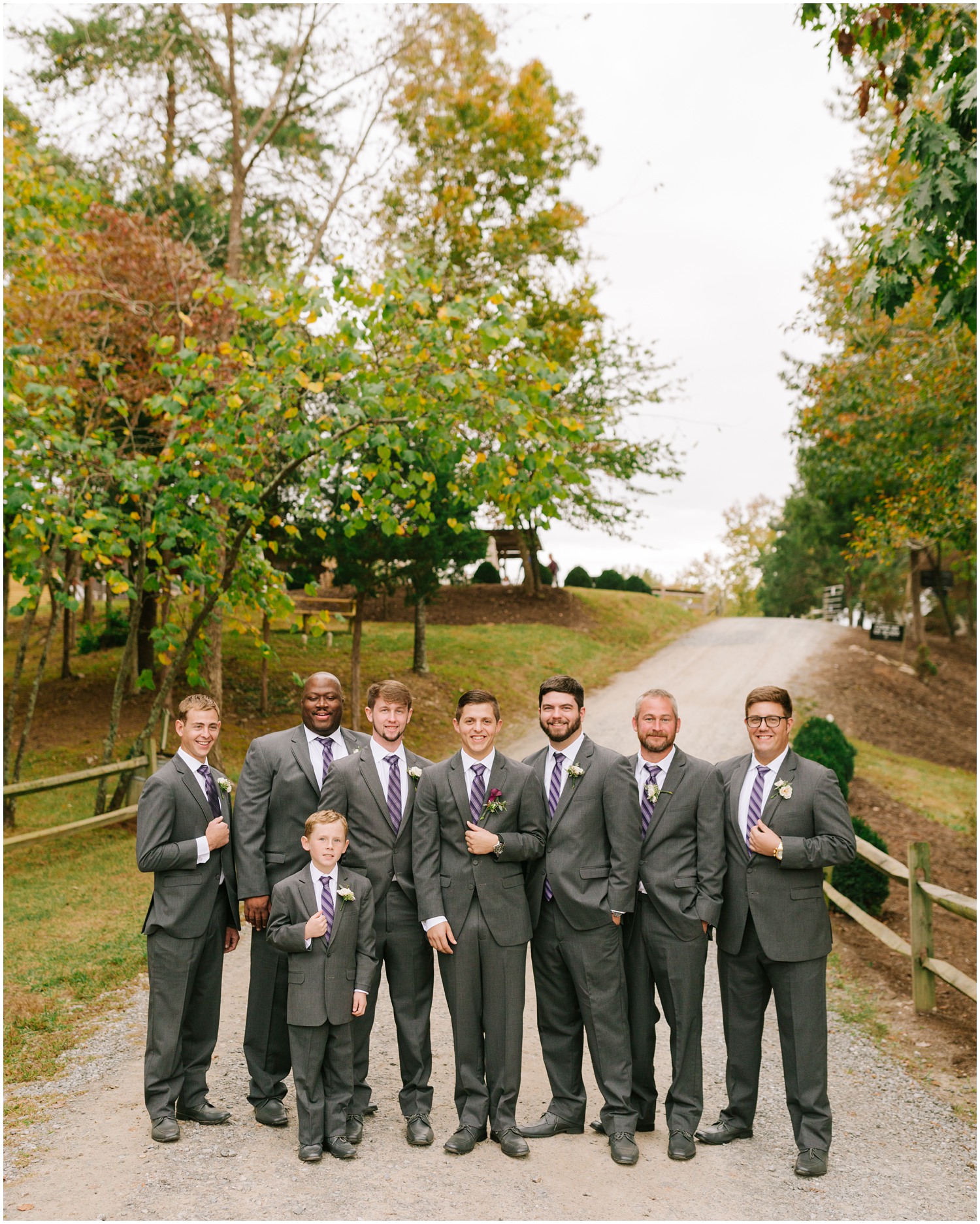 groomsmen in grey suits with purple ties pose before NC wedding 