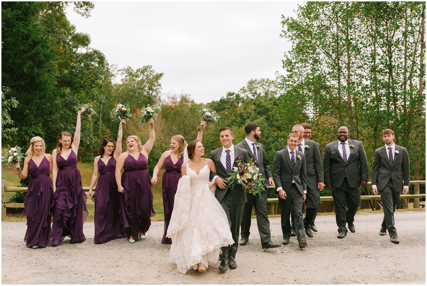 wedding party in plum dresses and grey suits walk