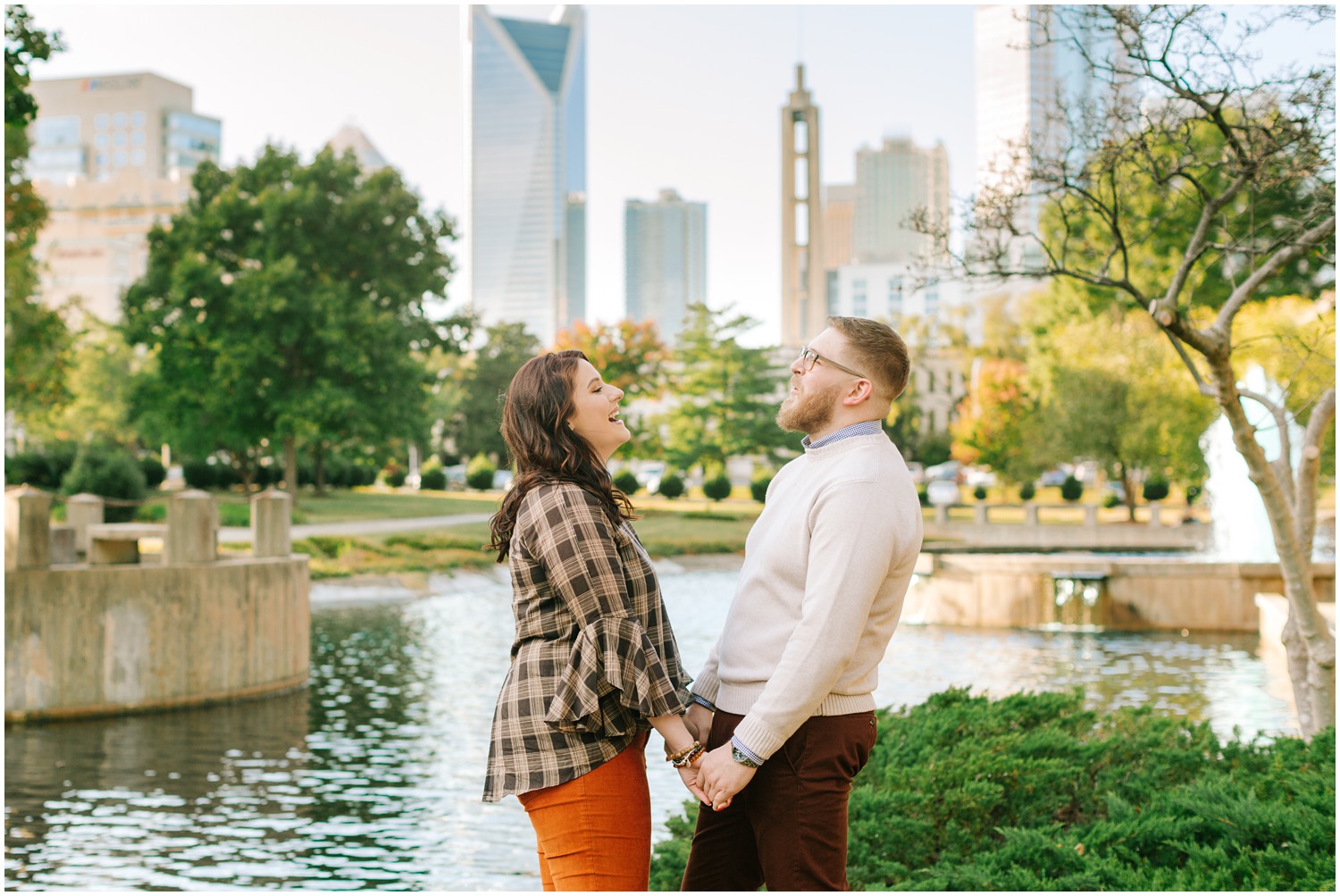 engagement session in Charlotte with skyline behind couple 