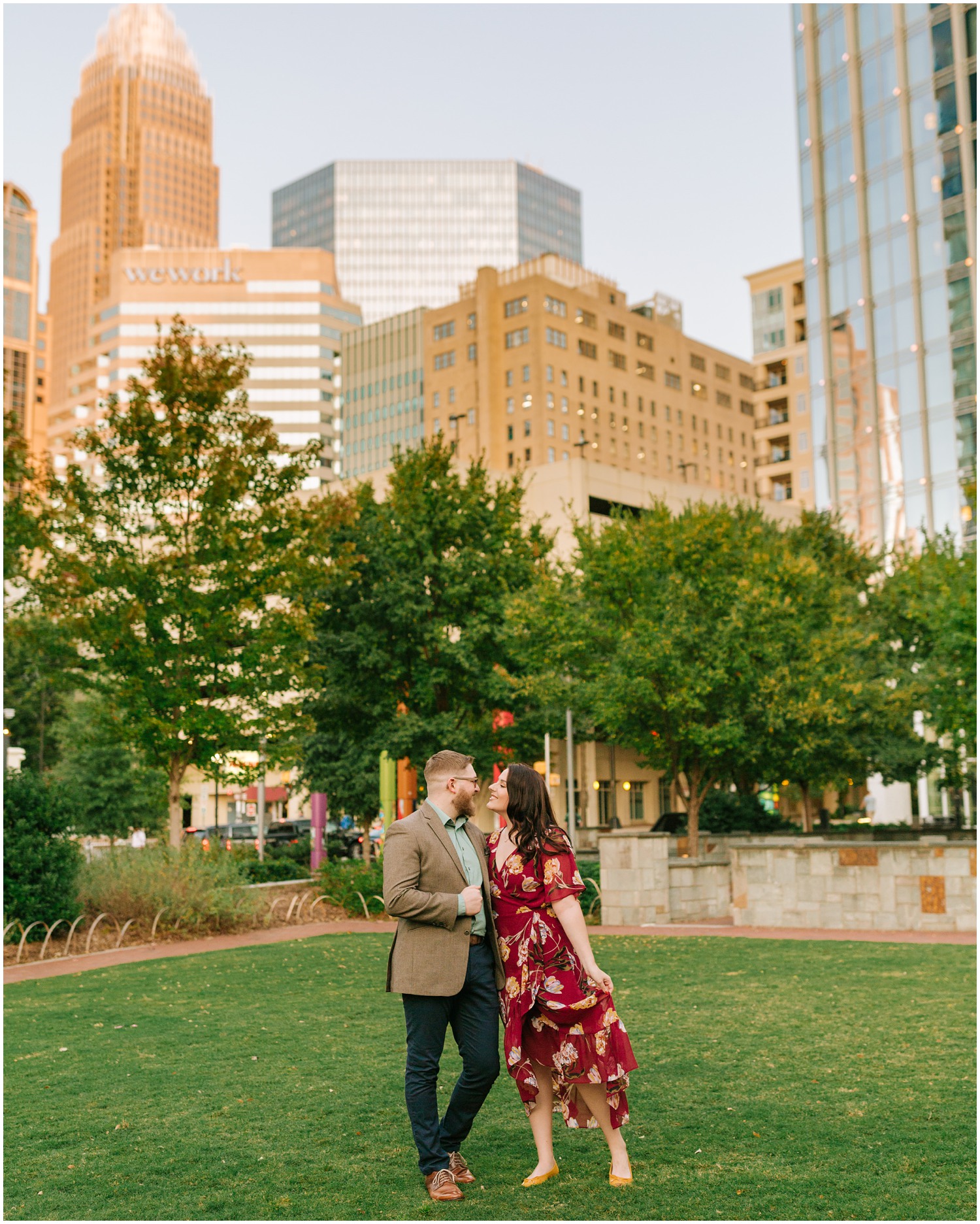 Uptown Charlotte engagement portraits on park lawn