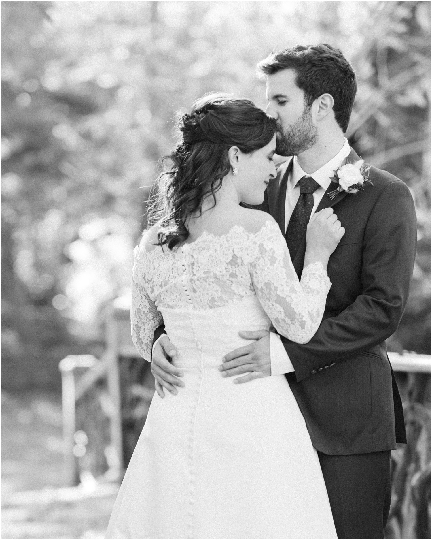 groom hugs bride and kisses her forehead during AVL wedding portraits