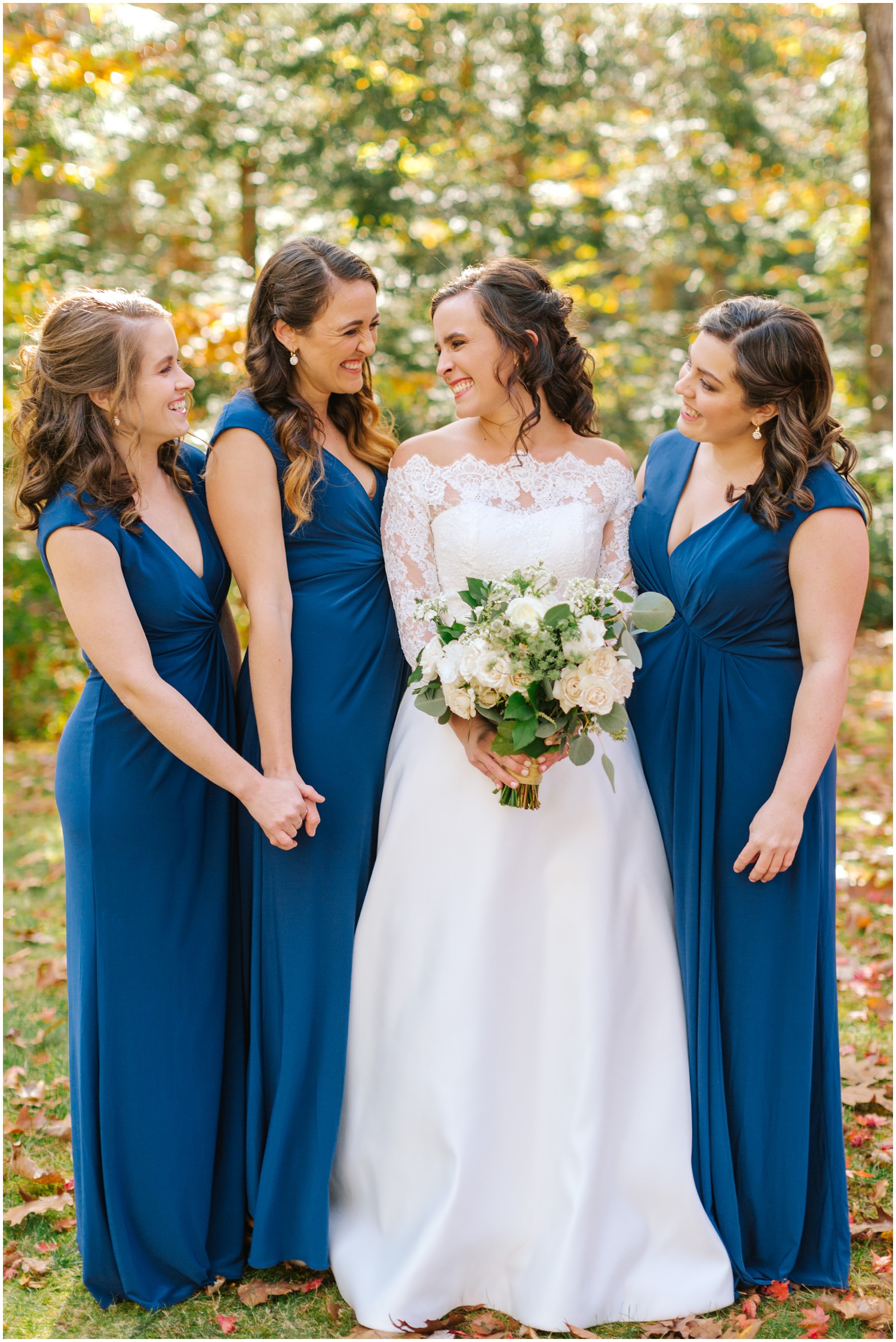 fall wedding portraits of bride with bridesmaids in blue gowns