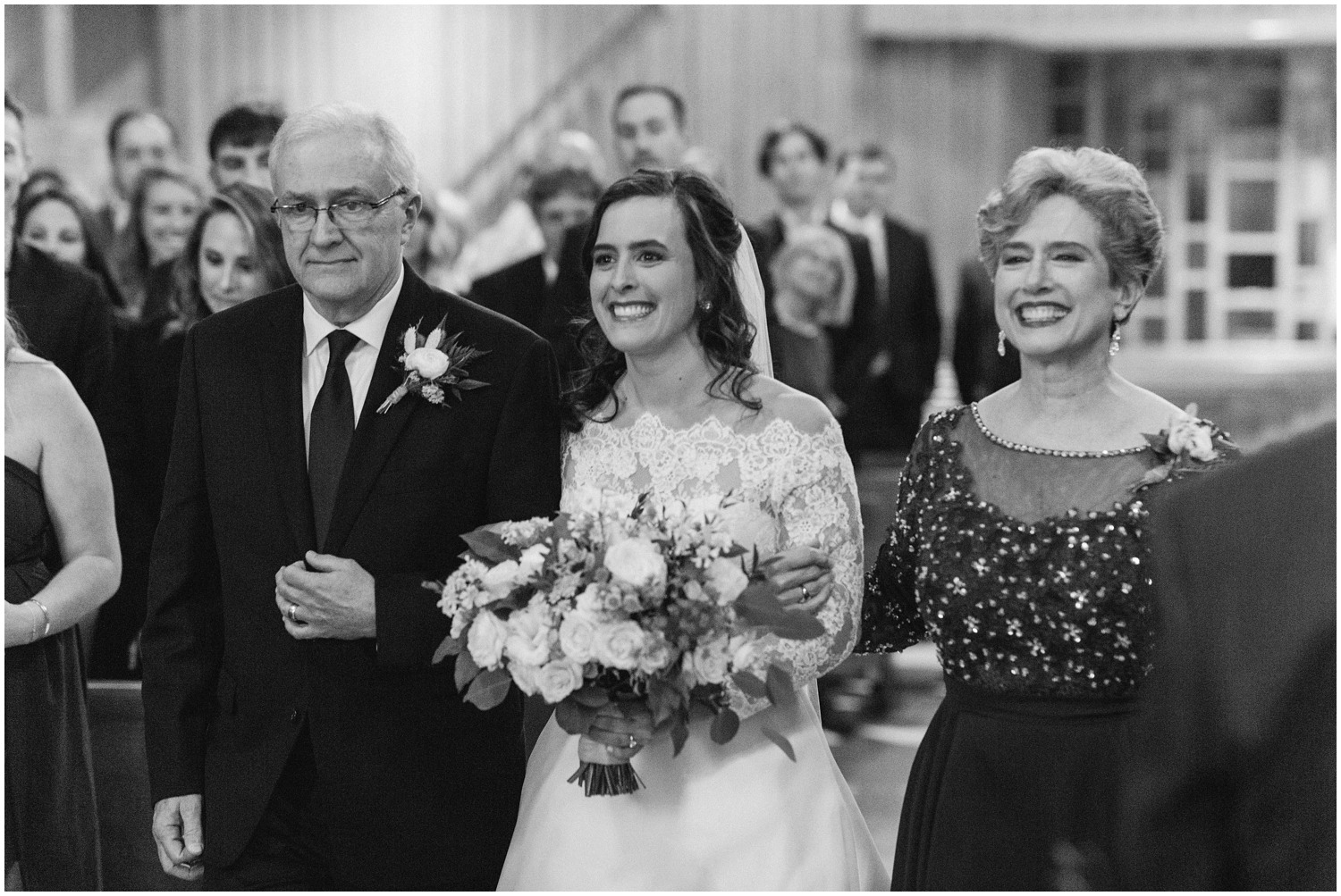 bride walks down aisle with parents during traditional church wedding in North Carolina