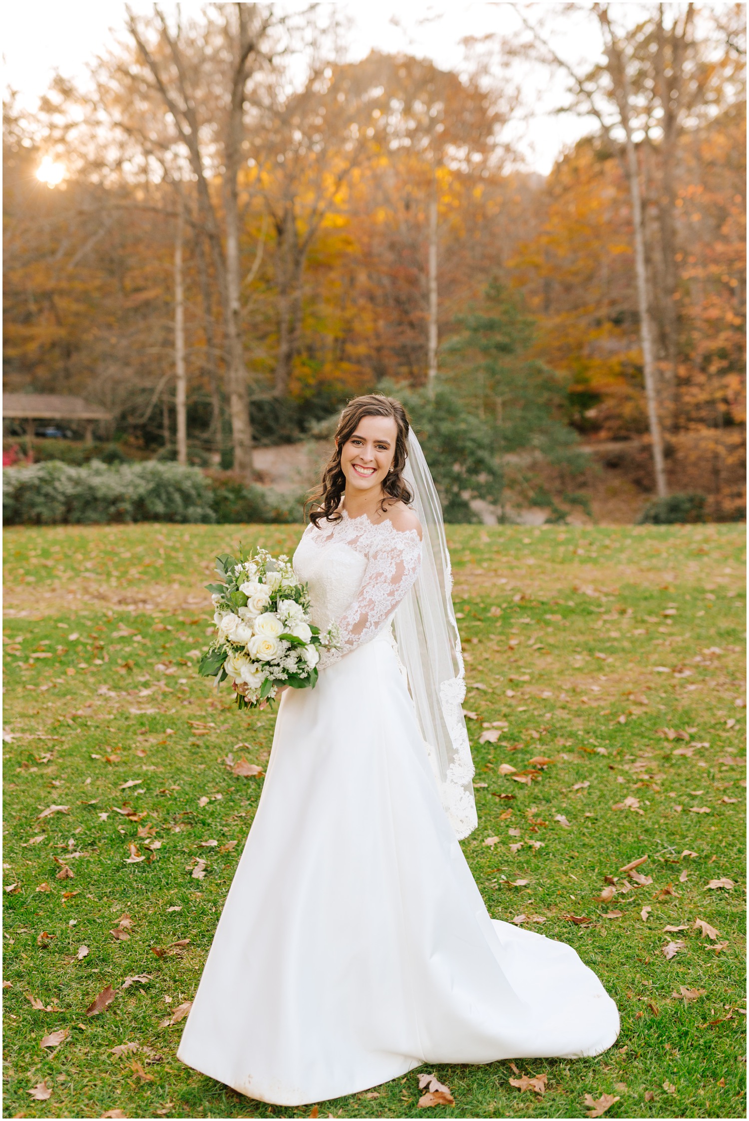 bride in wedding gown with lace sleeves and veil poses at Lake Eden Events