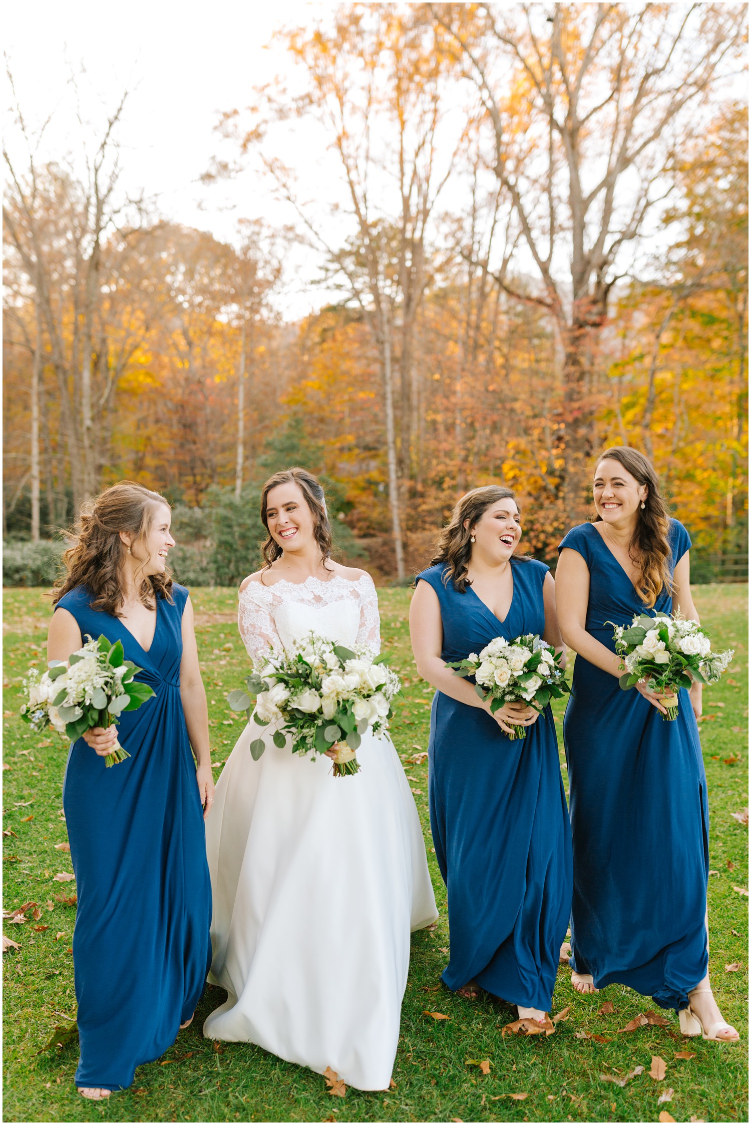bride and three bridesmaids in blue walk along Lake Eden Events