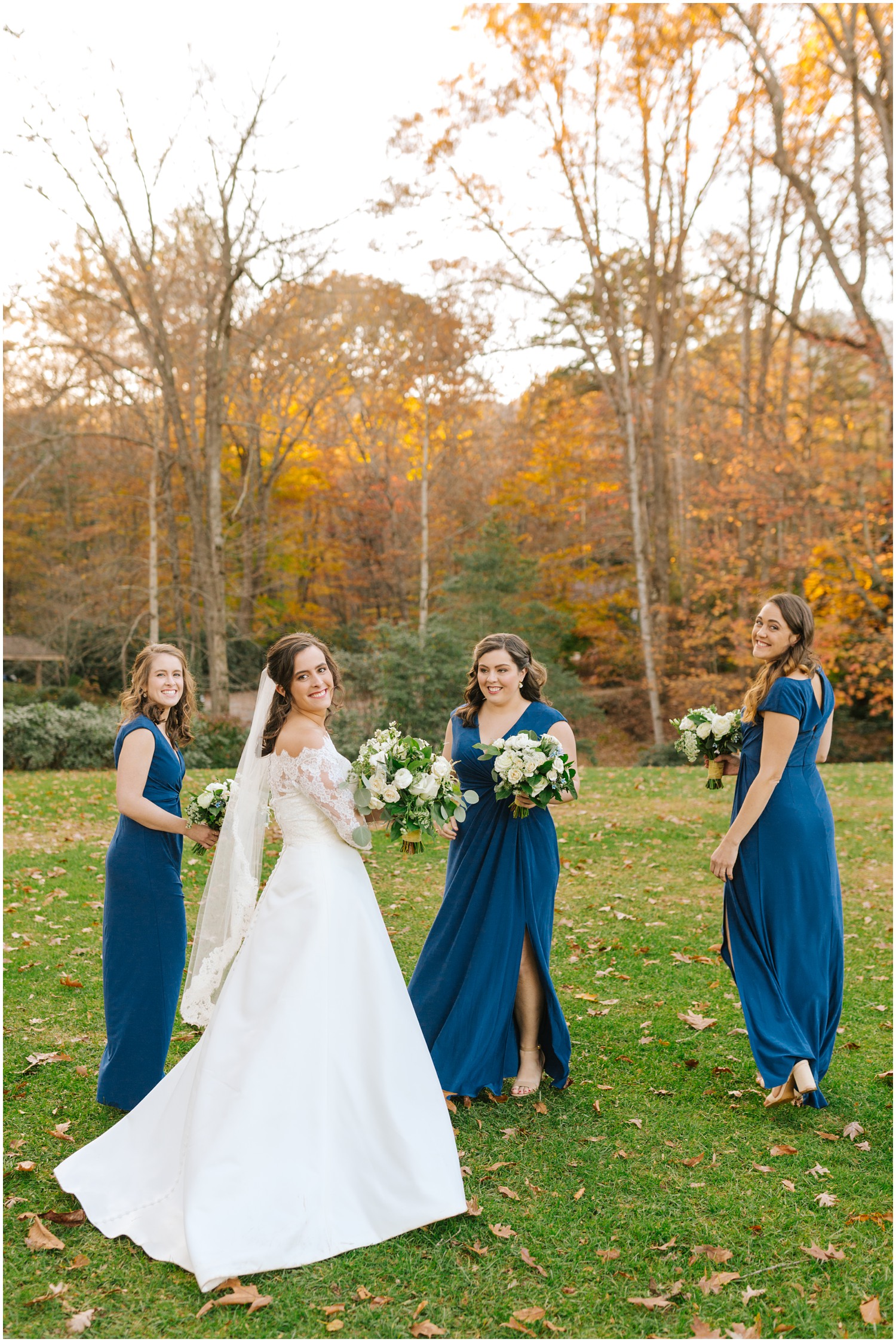 bride and bridesmaids in blue gowns twirl around during portraits at Lake Eden Events