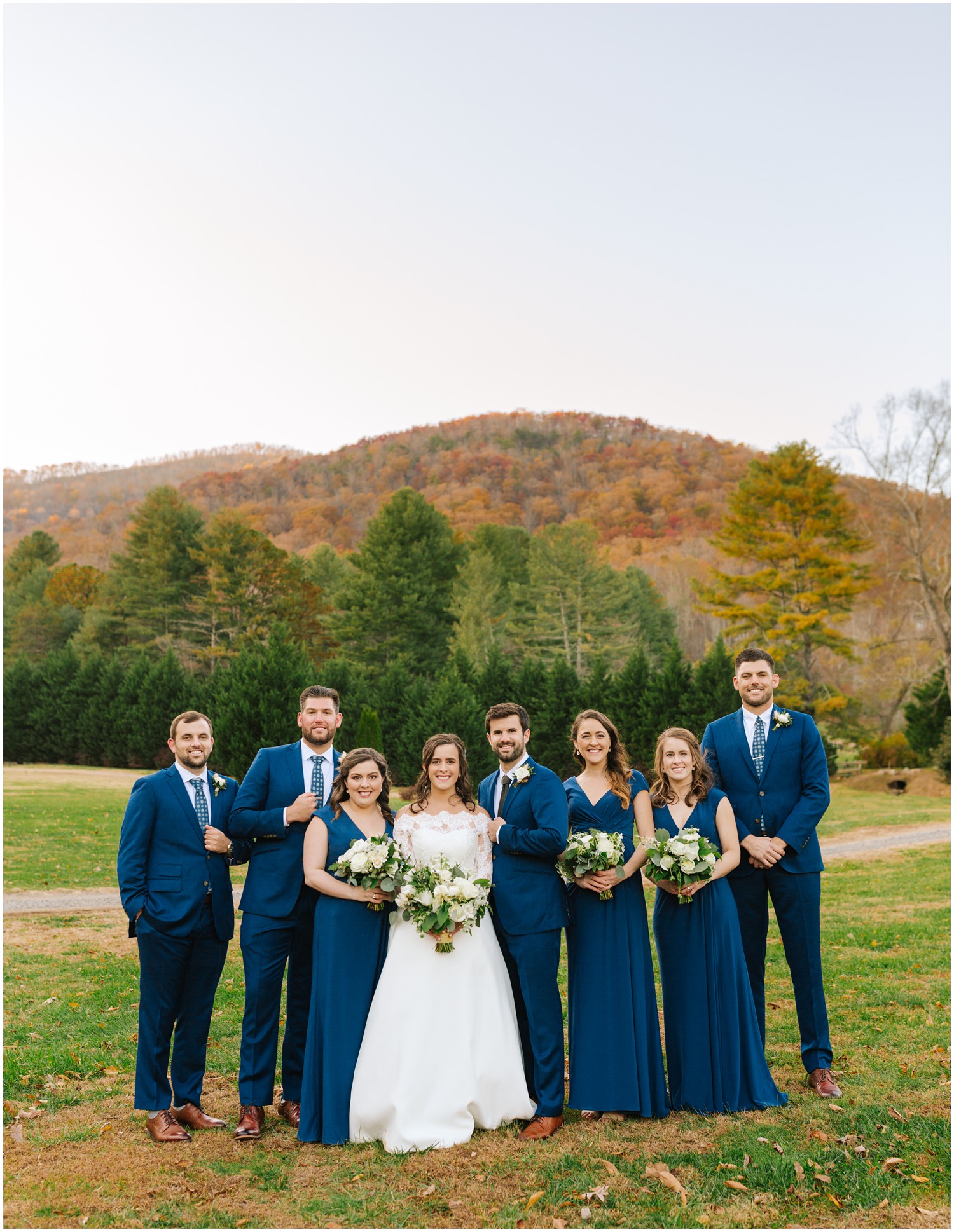 Asheville NC wedding party poses in front of mountains covered in leaves
