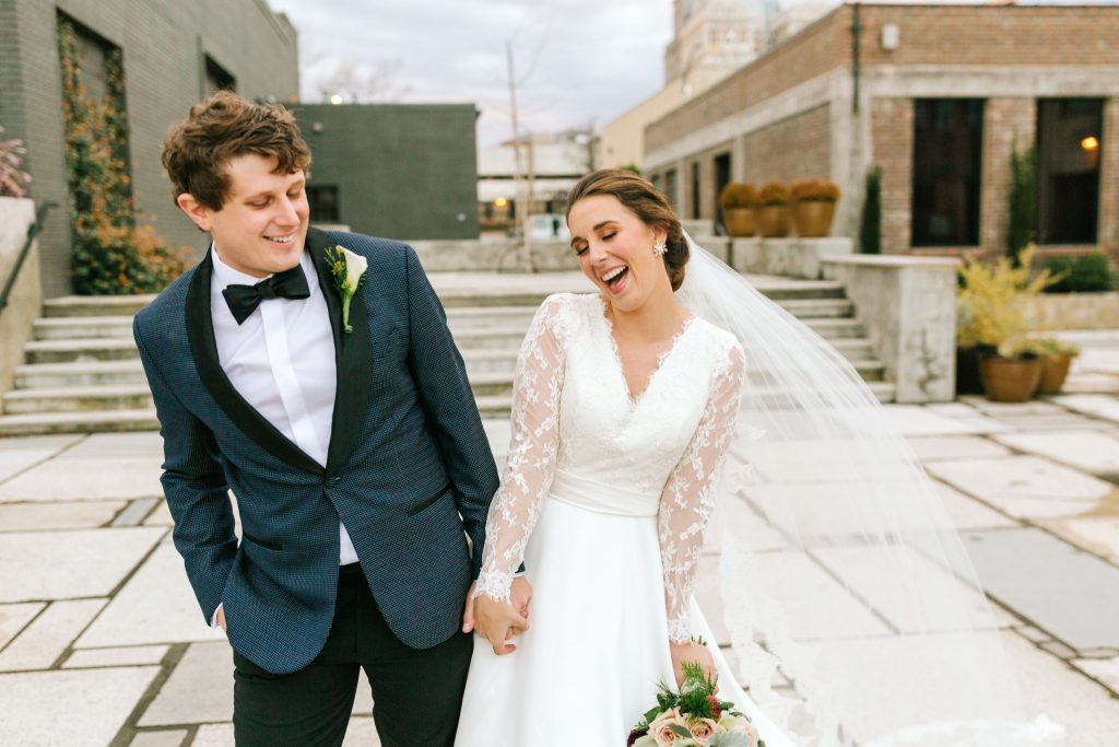 winston salem wedding photographer captures candid laugh of a couple on their wedding day at the Cadillac Service Garage in Greensboro, NC.