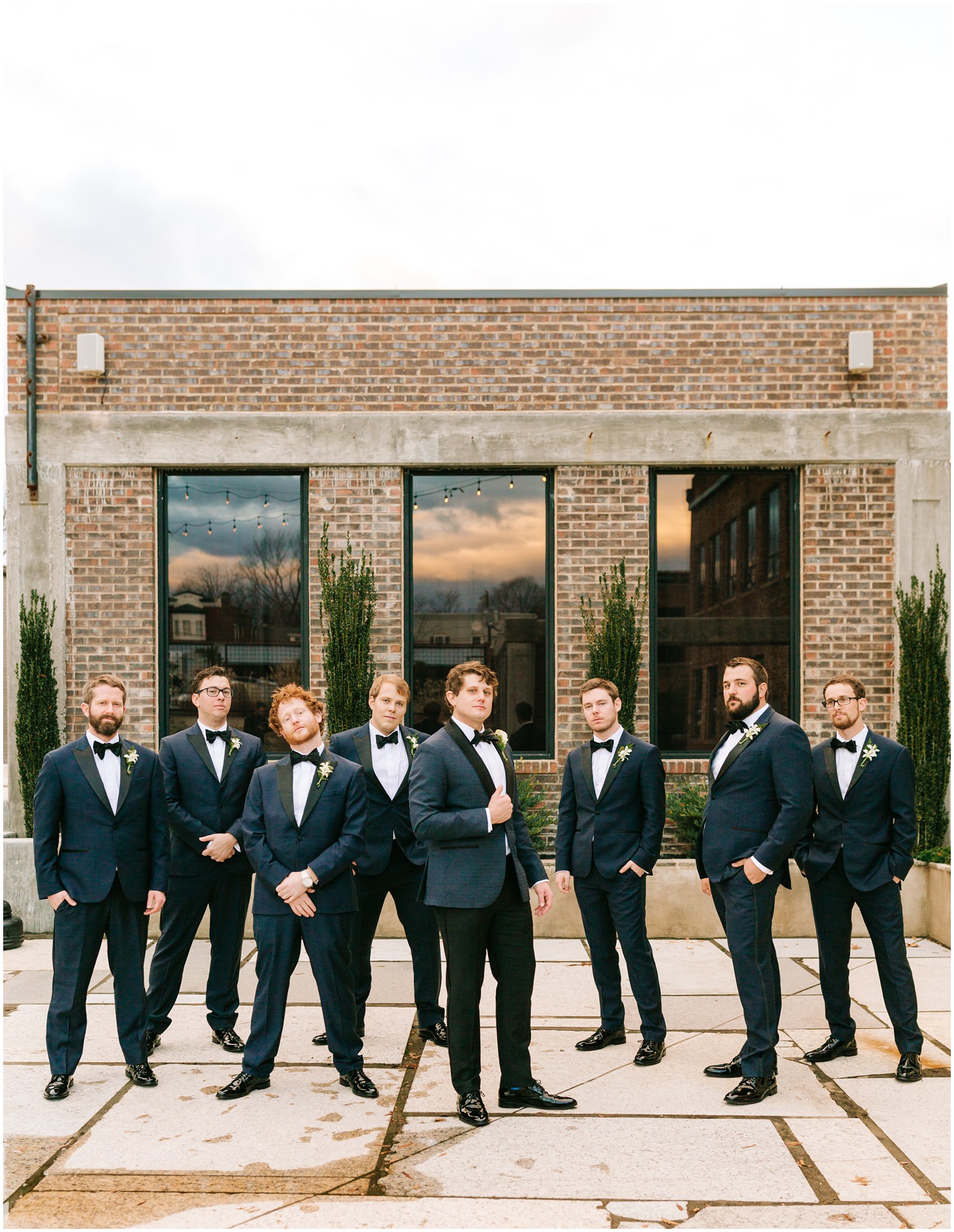 groomsmen pose outside Cadillac Service Garage photographed by Chelsea Renay Photography