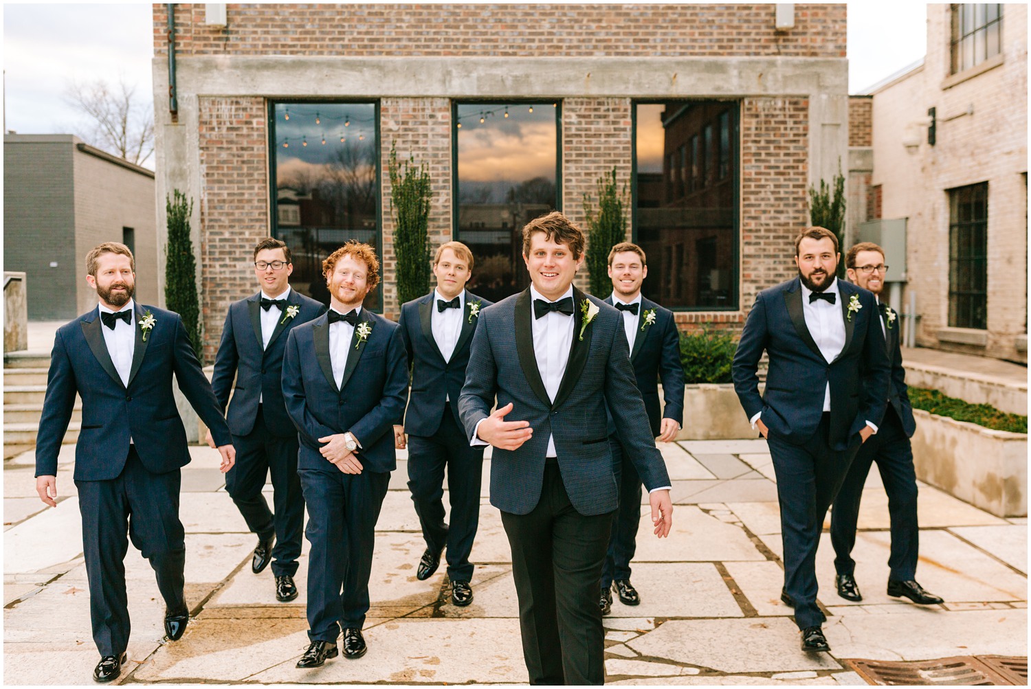 groom and groomsmen in navy blue and black suits walk towards photographer Chelsea Renay Photography