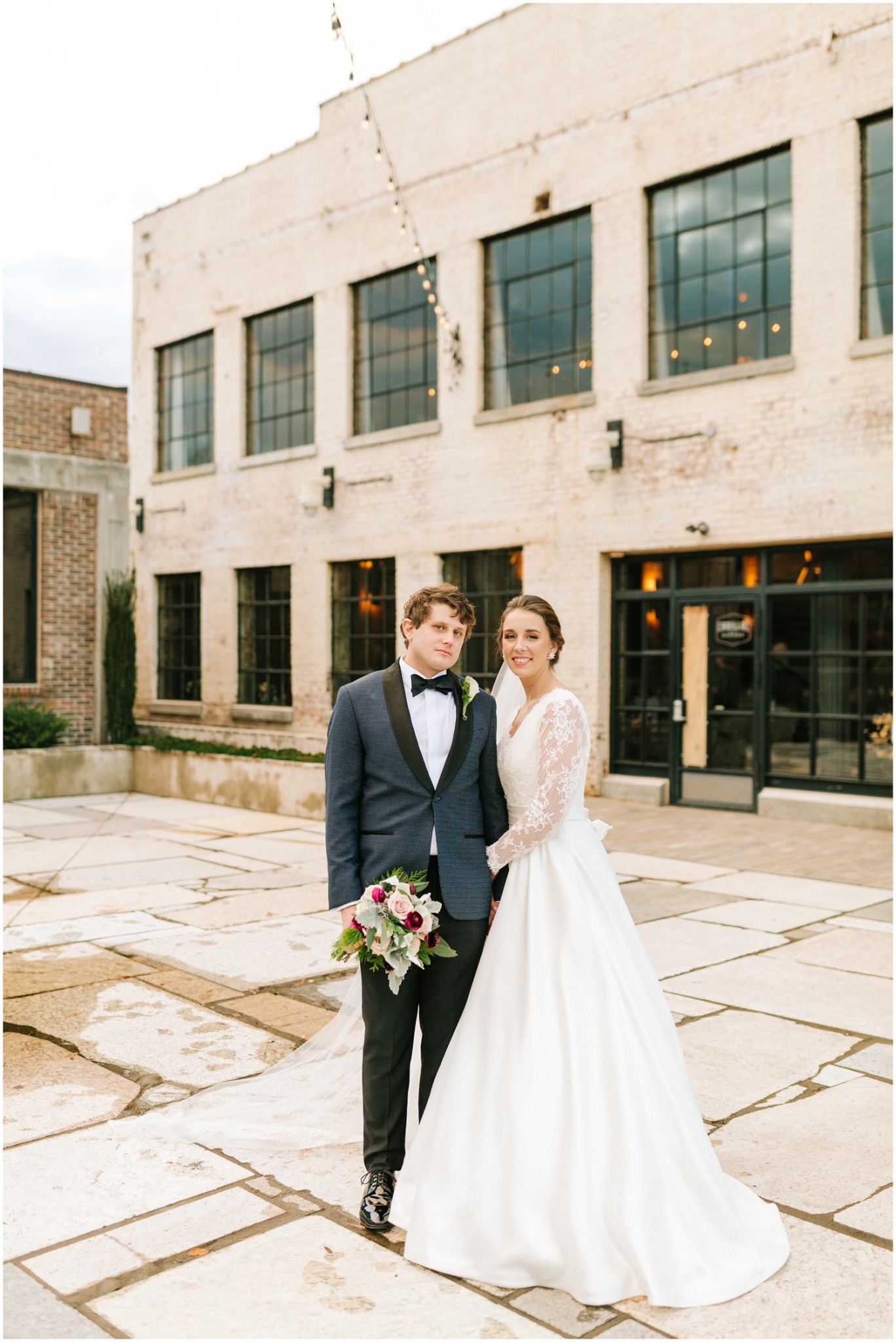 groom holds bride's bouquet and bride snuggles him for winter wedding portraits