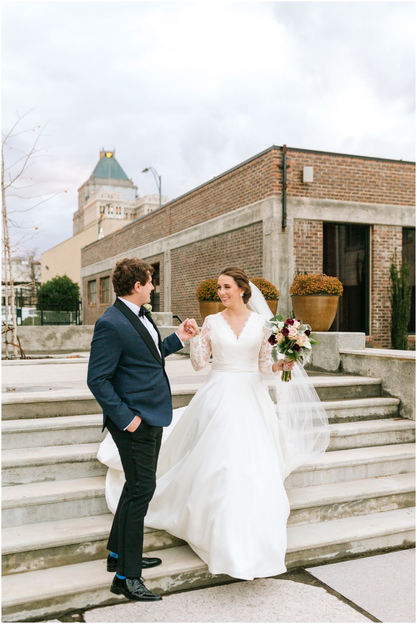 groom helps bride down steps in Greensboro NC photographed by Chelsea Renay Photography
