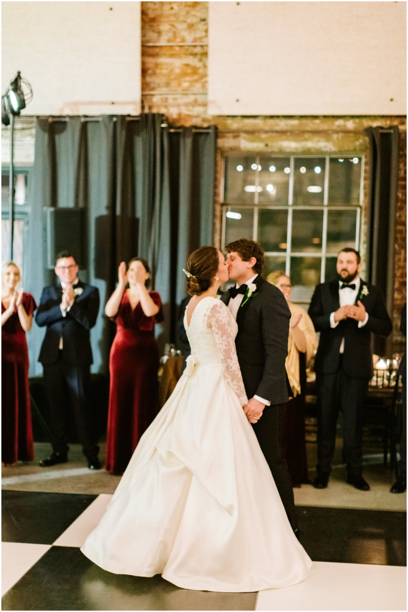 bride and groom kiss on dance floor after first dance 