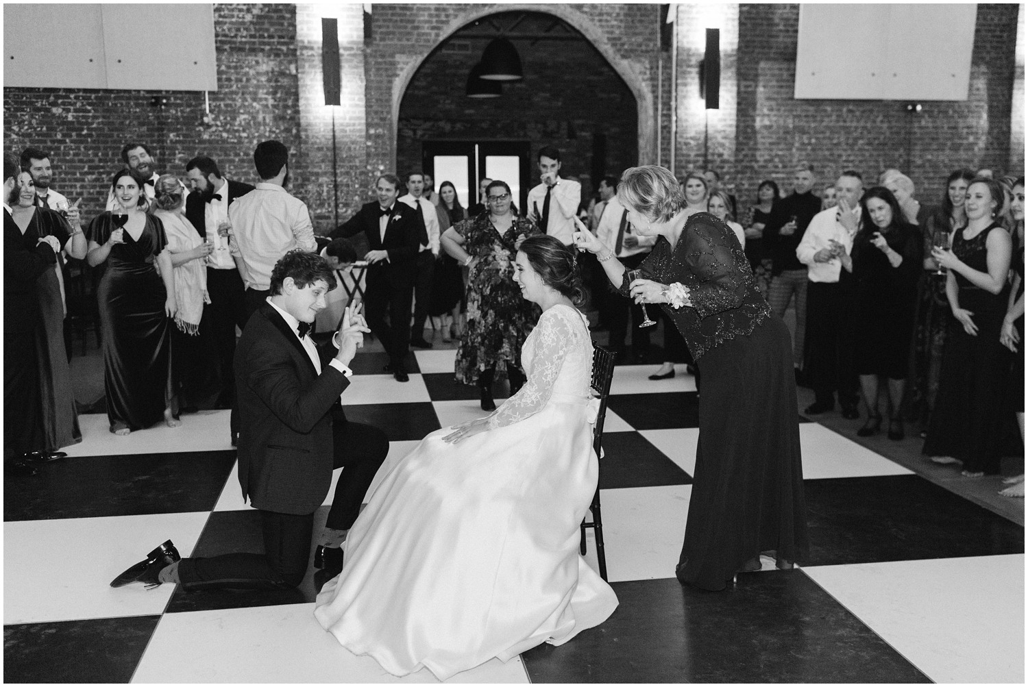 Chelsea Renay Photography photographs bride's mother teasing groom before garter toss